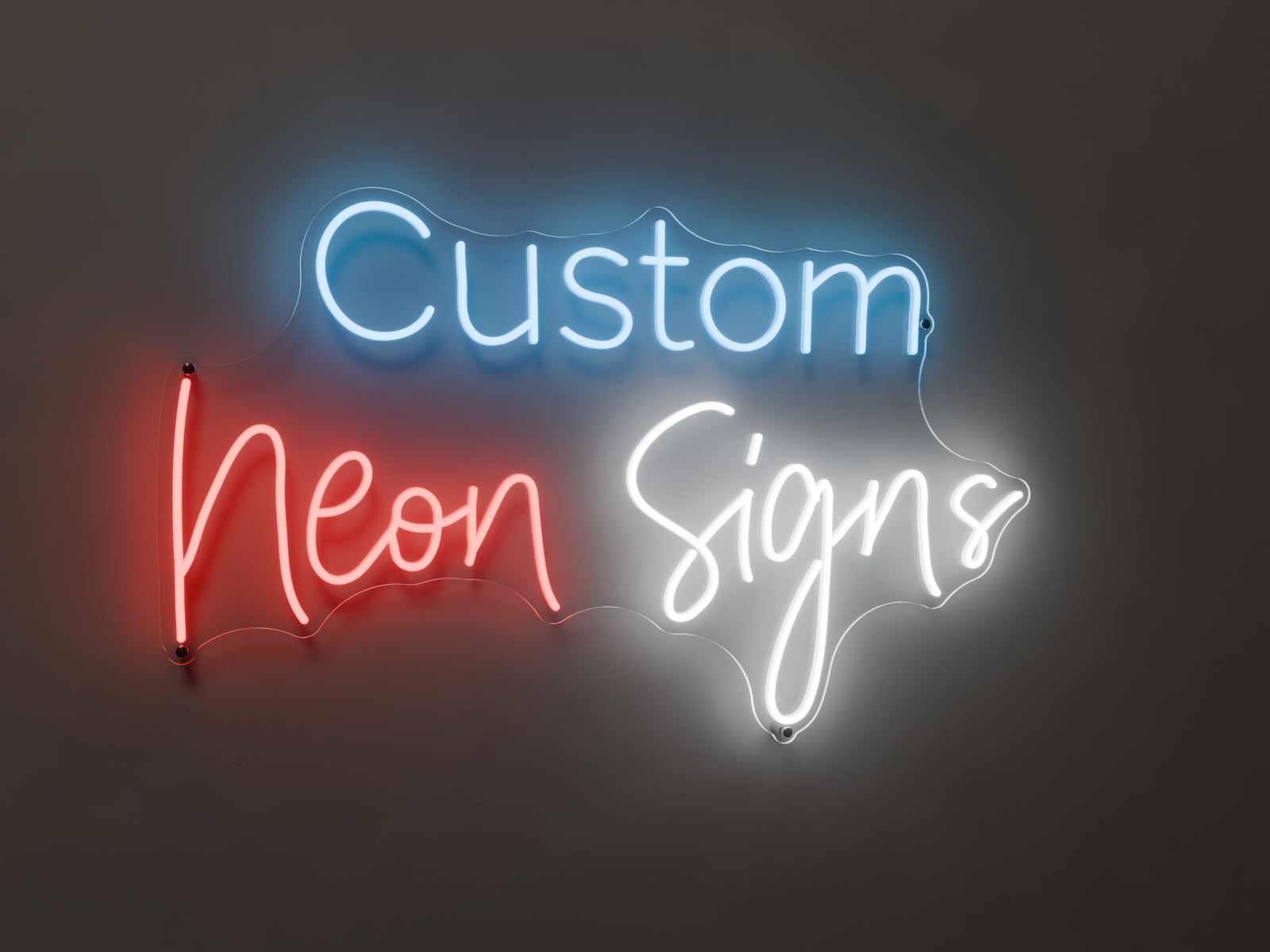LED neon sign reading Custom Neon Signs in blue, red and white, lit on a dark wall