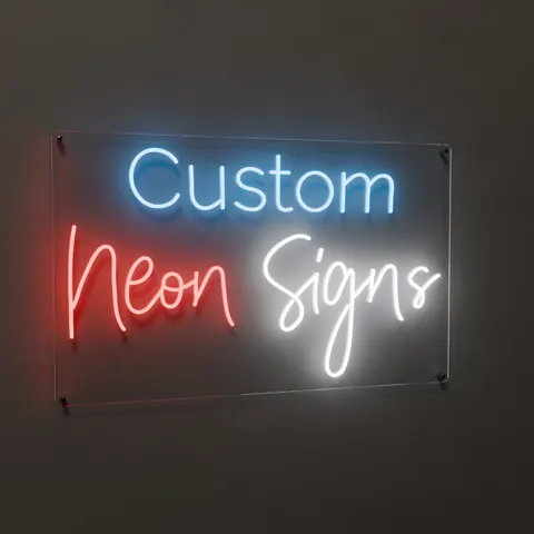 “Custom Neon Signs” LED neon sign lit on a dark wall, seen from a three-quarter angle