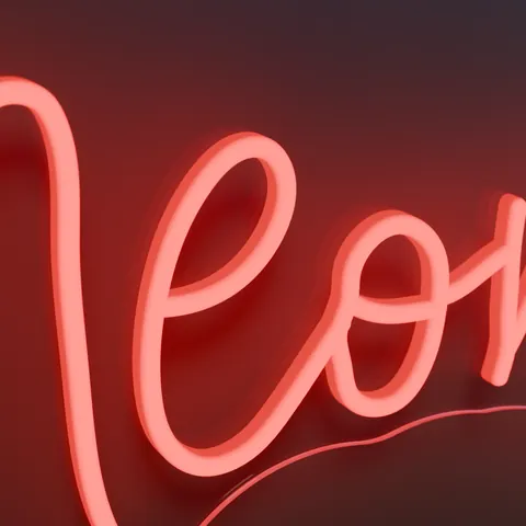Close-up of a red script LED neon tube, lit, on its clear acrylic board