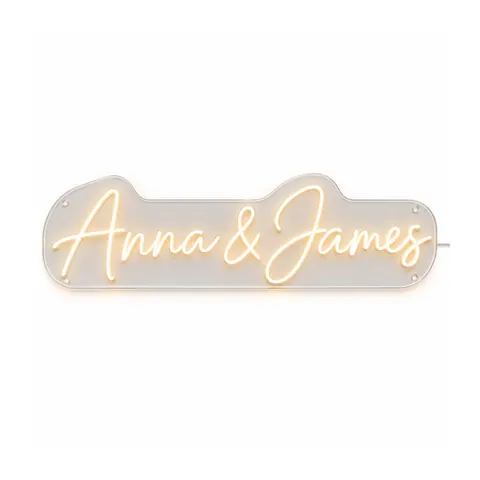 Wedding neon sign example: “Anna & James” in warm white LED neon script on a clear acrylic board, lit, on a white background