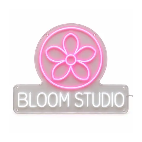 Logo neon sign example: a pink flower in a circle above “BLOOM STUDIO” in white neon capitals on clear acrylic, on a white background